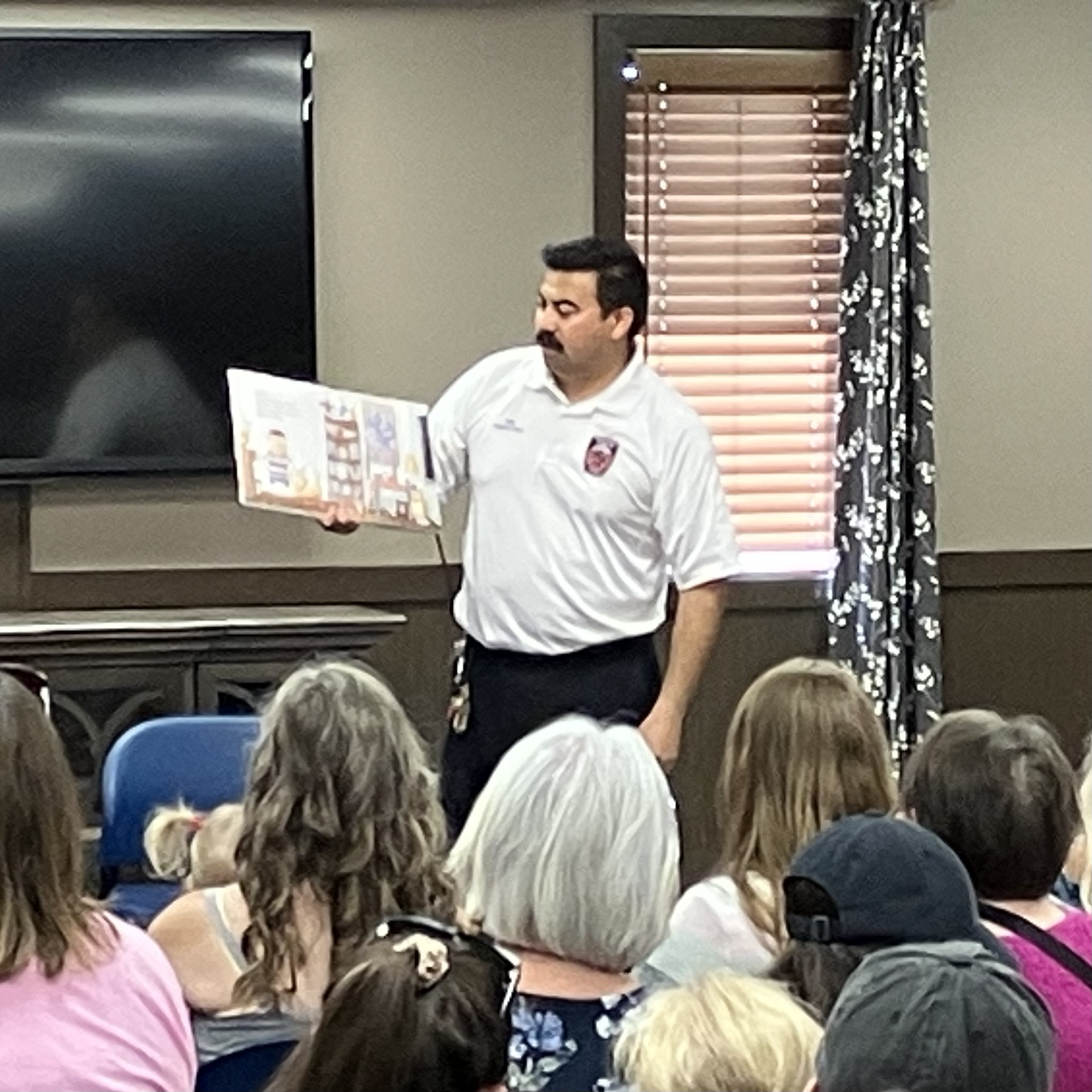 Picture of Firefighter Phil from the Saginaw Township Fire Department reading a story