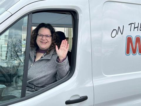 Outreach Library Assistant Beth Lasky waves from the Public Libraries of Saginaw's new Bookmobile