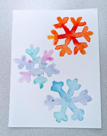 Watercolor painting of three snowflakes 