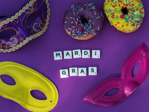 Masks and donuts surround the words "Mardi Gras"