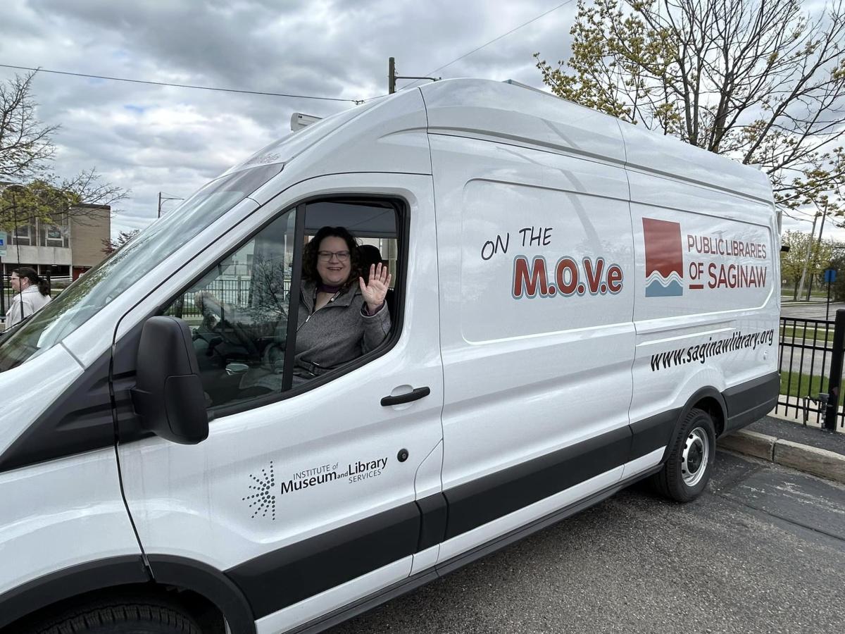 Outreach Library Assistant Beth Lasky waves from the Public Libraries of Saginaw's new Bookmobile