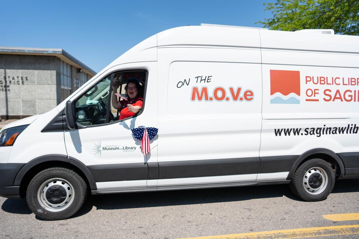 Outreach Library Assistant Beth Lasky waves from the Public Libraries of Saginaw's Bookmobile