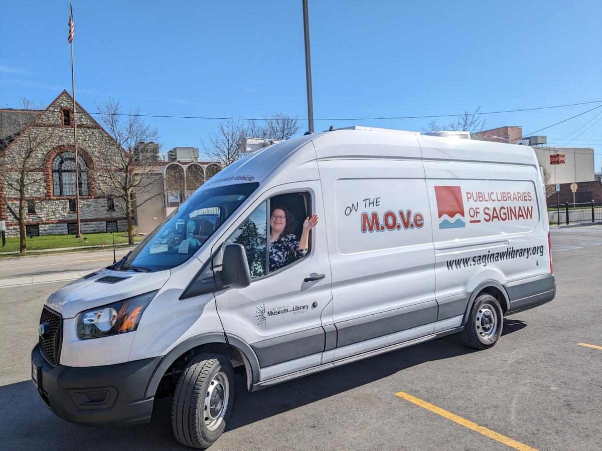 Outreach Library Assistant Beth Lasky waves from the Public Libraries of Saginaw's new Bookmobile